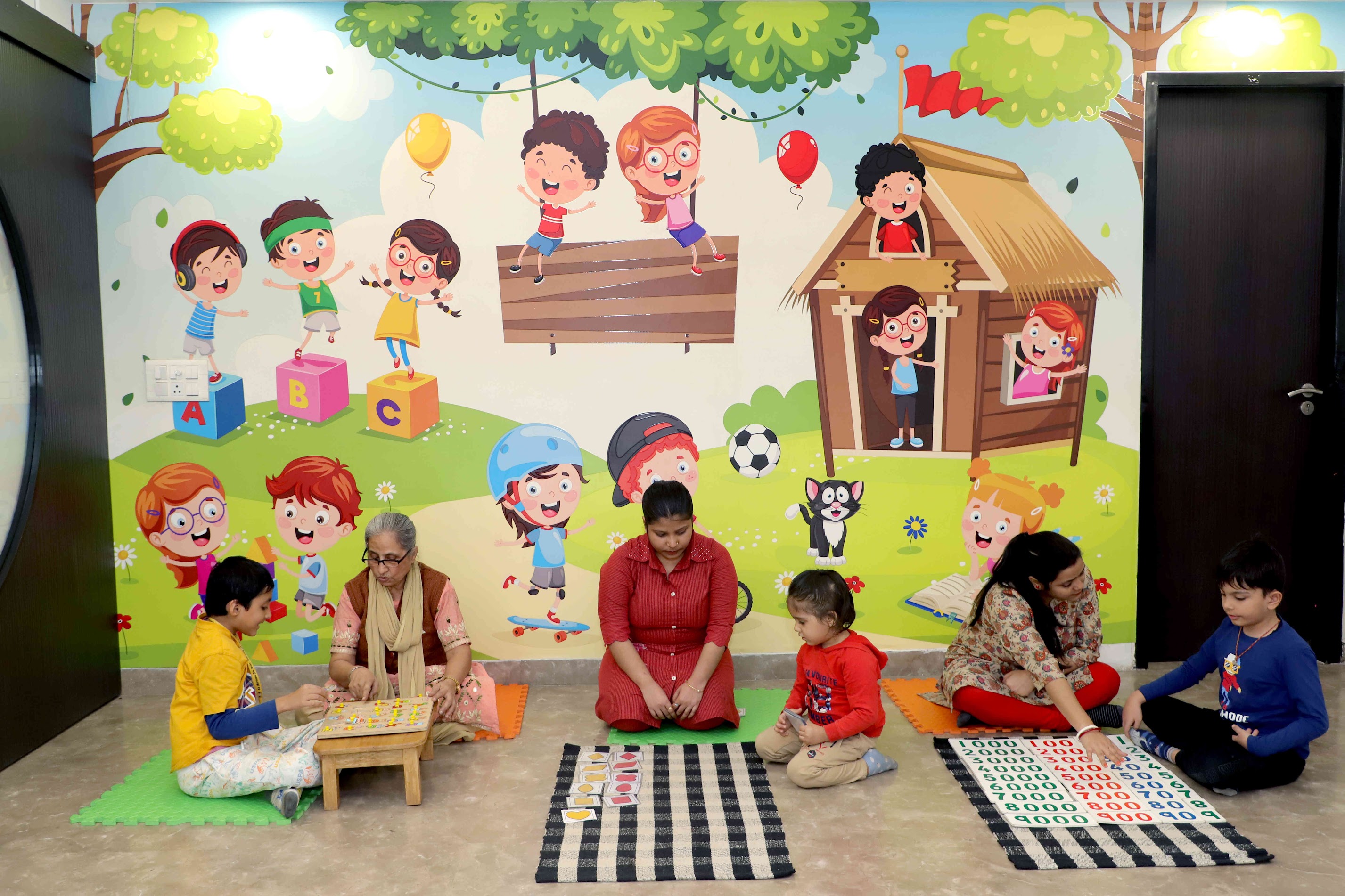 Children and teachers in a bright Evaara classroom with a colorful learning mural